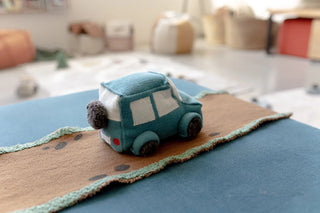 Stoffen blauwe Ride & Roll-safarijeep op een uitgerolde weg.