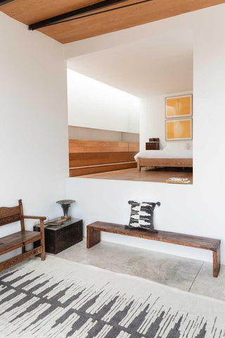 Zagros Natural Grey vloerkleed bij een houten bank