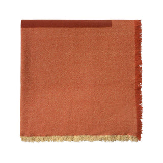 Opgevouwen Vertical-tafelkleed in terracottarood met franjes.