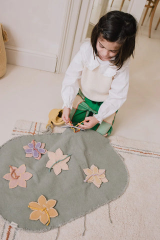 Kind speelt met bloemen op de Flower Garden-speelmat.