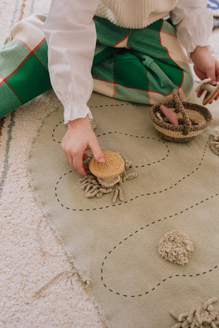 Kind speelt met een slak op de Snail-speelmat.