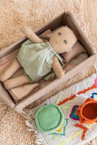 Mini Lorena Nari pop in haar mandbedje op een vloerkleed
