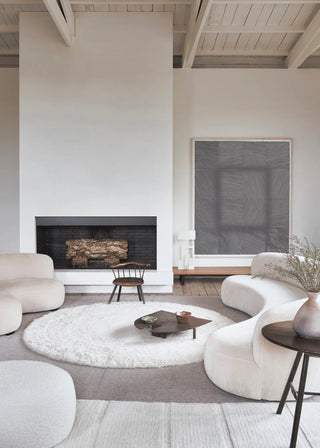 Rond wit Arctic-vloerkleed met concentrische structuur in een zithoek.