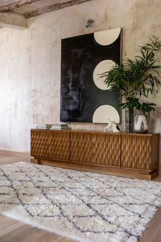 Wollen Bereber-vloerkleed met donkere ruiten bij een houten dressoir.