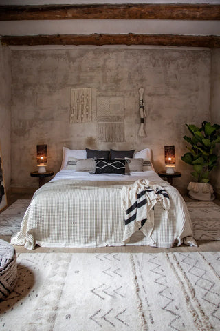 Lakoda-vloerkleden met geometrische motieven in een slaapkamer rond een tweepersoonsbed.