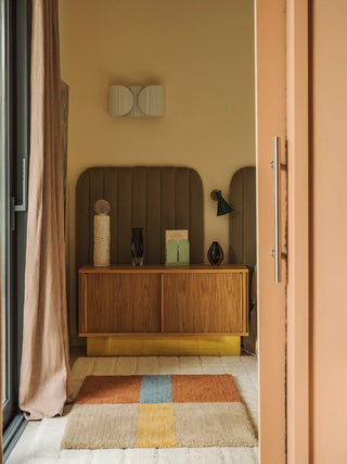 Kaneelkleurig vloerkleed met blauwgele streep voor een kast.