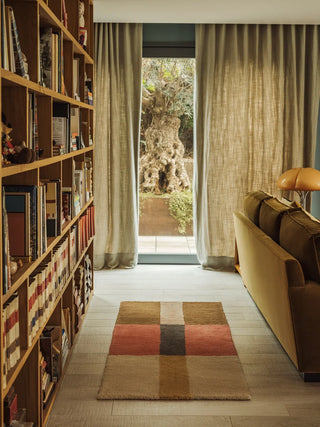 Lorena Canals Chroma Spiced Coral loper tussen boekenkast en bank