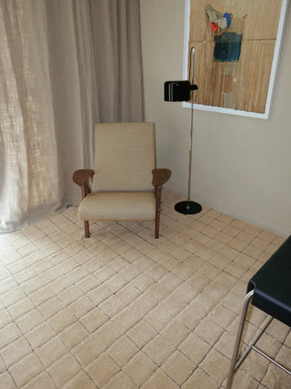 Amberkleurig Mosaic-vloerkleed onder een fauteuil.