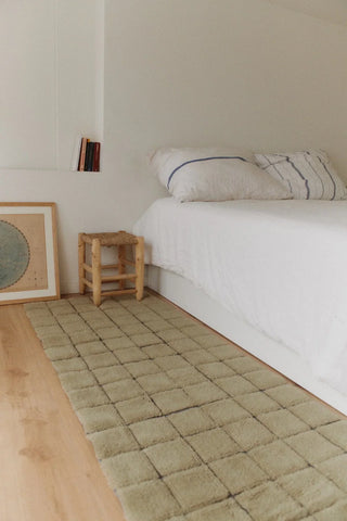 Lorena Canals Mosaic Moss vloerkleed naast een bed
