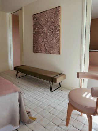 Naturel Mosaic-vloerkleed met rasterpatroon bij een bankje en roze stoel.