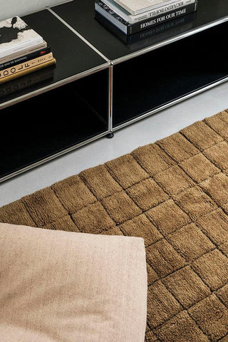 Mosaic Ochre loper naast een laag meubel en stoel
