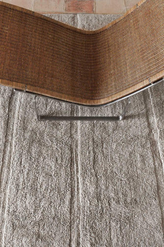 Steppe Sheep Grey loper onder een rotan stoel