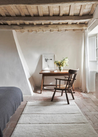 Wit Steppe-vloerkleed met beige franjeranden in een slaapkamer bij een bureau.