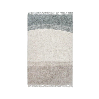 Into the Blue-vloerkleed met grijze, lichte en blauwgroene banen en franjes.