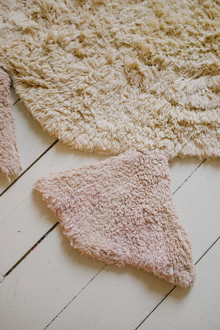 Detail van een roze poot van het eendenvloerkleed.
