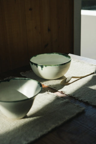 De naturel Legacy-placemat op een gedekte tafel.