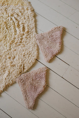 Detail van de twee roze poten van het eendenvloerkleed.