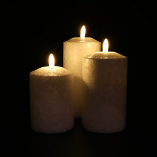 Witte smalle Marble ledkaarsen in drie formaten, brandend tegen een donkere achtergrond van Mansion atmosphere