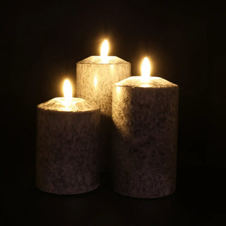 Zwarte smalle Marble ledkaarsen in drie formaten, brandend tegen een donkere achtergrond van Mansion atmosphere