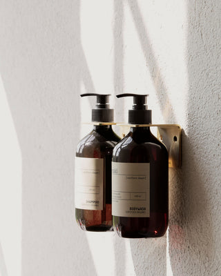 Meraki shampoo en body wash in een wandhouder in een lichte badkamer