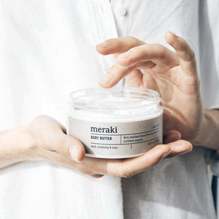 Meraki Silky Mist body butter wordt met de vingers uit de glazen pot genomen