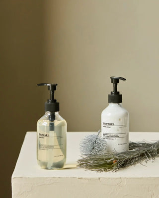 Gift box Winter Whisp Handzeep & Lotion - 2x275ml van Meraki, met handzeep en lotion naast groen op een lichte wastafel