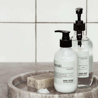 Meraki Silky Mist handlotion en handzeep met zwarte pomp op een badkamerblad