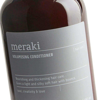 Detail van het grijze etiket op de Meraki Volumising Conditioner-pompflacon