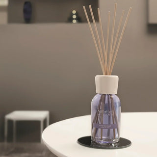 Blanke Millefiori geurstokjes in een glazen diffuser op een bijzettafel