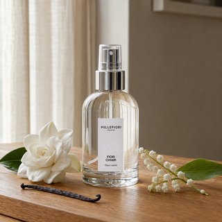 Millefiori Milano Home Spray 100 ml Fiori Chiari op een houten tafel met gardenia, lelietje-van-dalen en vanille in zacht raamlicht.