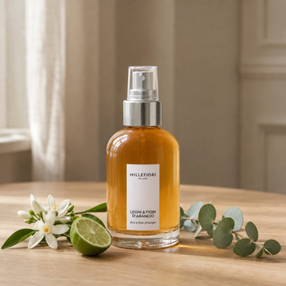 Millefiori Milano Home Spray 100 ml Legni e Fiori dArancio op een eiken tafeltje met oranjebloesem, bergamot en eucalyptus.