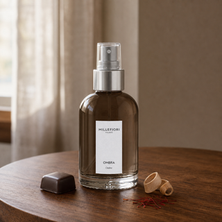 Millefiori Milano Home Spray 100 ml Ombra op een notenhouten tafel met chocoladepraliné, sandelhout en saffraan.
