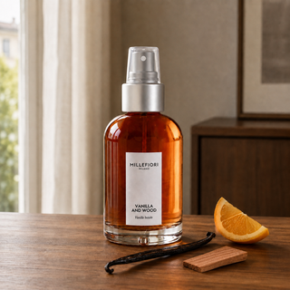 Millefiori Vanilla & Wood roomspray op een houten console met vanille, cederhout en sinaasappel.