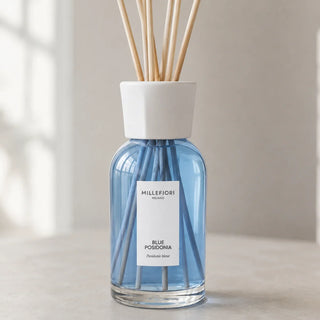 Detail van Millefiori Milano Reed Diffuser 250 ml Blue Posidonia met lichtblauw glas, wit etiket en gefacetteerde witte kraag.