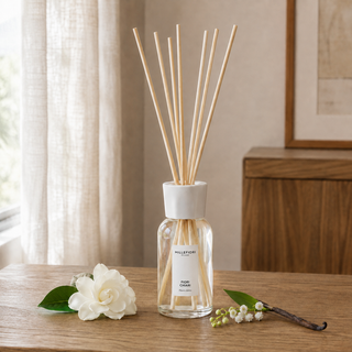 Millefiori Milano Reed Diffuser 250 ml Fiori Chiari op een houten console met gardenia, lelietje-van-dalen en vanille in zacht raamlicht.