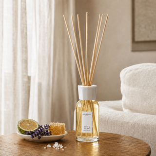 Millefiori Milano Reed Diffuser 250 ml Honey & Sea Salt op een houten tafel met bergamot, lavendel, honingraat en zout als verwijzing naar de geur.
