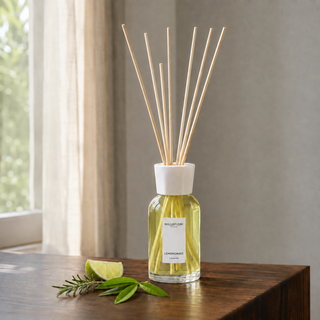Millefiori Lemon Grass geurstokjes op een houten console met limoen, rozemarijn en verbena.