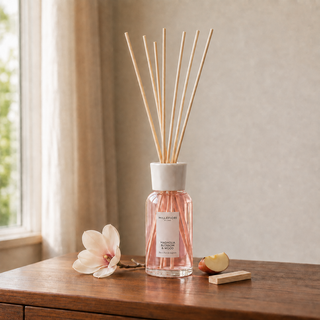 Millefiori Magnolia Blossom & Wood geurstokjes op een houten console met magnolia, appel en sandelhout.