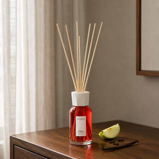 Millefiori Milano Reed Diffuser 250 ml Mela & Cannella op een notenhouten console met groene appel, kruidnagel en vanille.