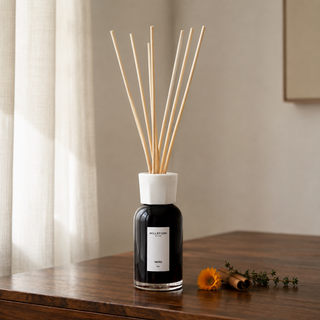 Millefiori Milano Reed Diffuser 250 ml Nero in een warm Europees interieur, met goudsbloem, kaneel en tijm.