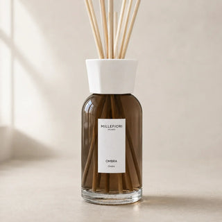 Detail van Millefiori Milano Reed Diffuser 250 ml Ombra met rookbruin glas, witte gefacetteerde kraag en natuurlijke geurstokjes.