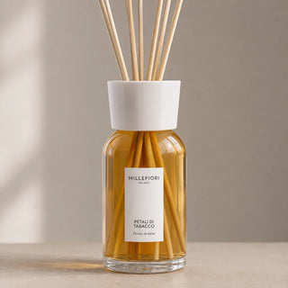 Detail van Millefiori Milano Reed Diffuser 250 ml Petali di Tabacco met amberkleurig glas, wit etiket en witte kraag.