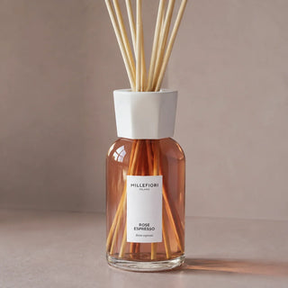 Detail van de glazen flacon, witte kraag en naturel geurstokjes van Millefiori Milano Reed Diffuser 250 ml Rose Espresso.