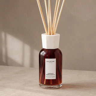 Detail van de glazen flacon, witte kraag en naturel geurstokjes van Millefiori Milano Reed Diffuser 250 ml Sandalo Bergamotto.