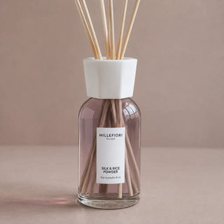 Detail van de glazen flacon, witte kraag en naturel geurstokjes van Millefiori Milano Reed Diffuser 250 ml Silk & Rice Powder.