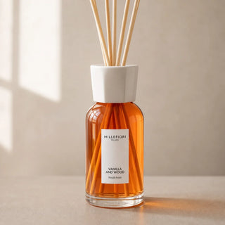 Detail van Millefiori Milano Reed Diffuser 250 ml Vanilla & Wood met amberkleurig glas, wit etiket, witte kraag en natuurlijke geurstokjes.