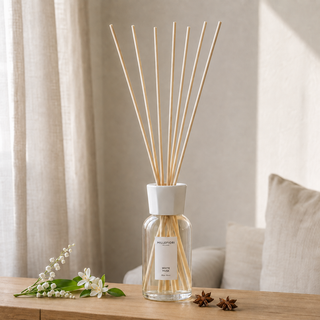 Millefiori Milano Reed Diffuser 250 ml White Musk op een houten console met witte bloemen en steranijs als verwijzing naar de geur.