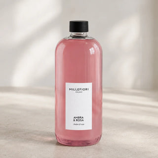 Detail van Milano Refill 500 ml Ambra & Rosa van Millefiori met zwarte schroefdop, laag wit etiket en navulfles in zacht raamlicht.