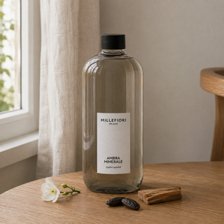 Milano Refill 500 ml Ambra Minerale van Millefiori in een Europees interieur met witte bloemen, tonkabonen en cederhout.