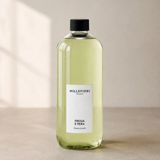 Detail van Milano Refill 500 ml Fresia e Pera van Millefiori met zwarte schroefdop, laag wit etiket en navulfles in zacht raamlicht.